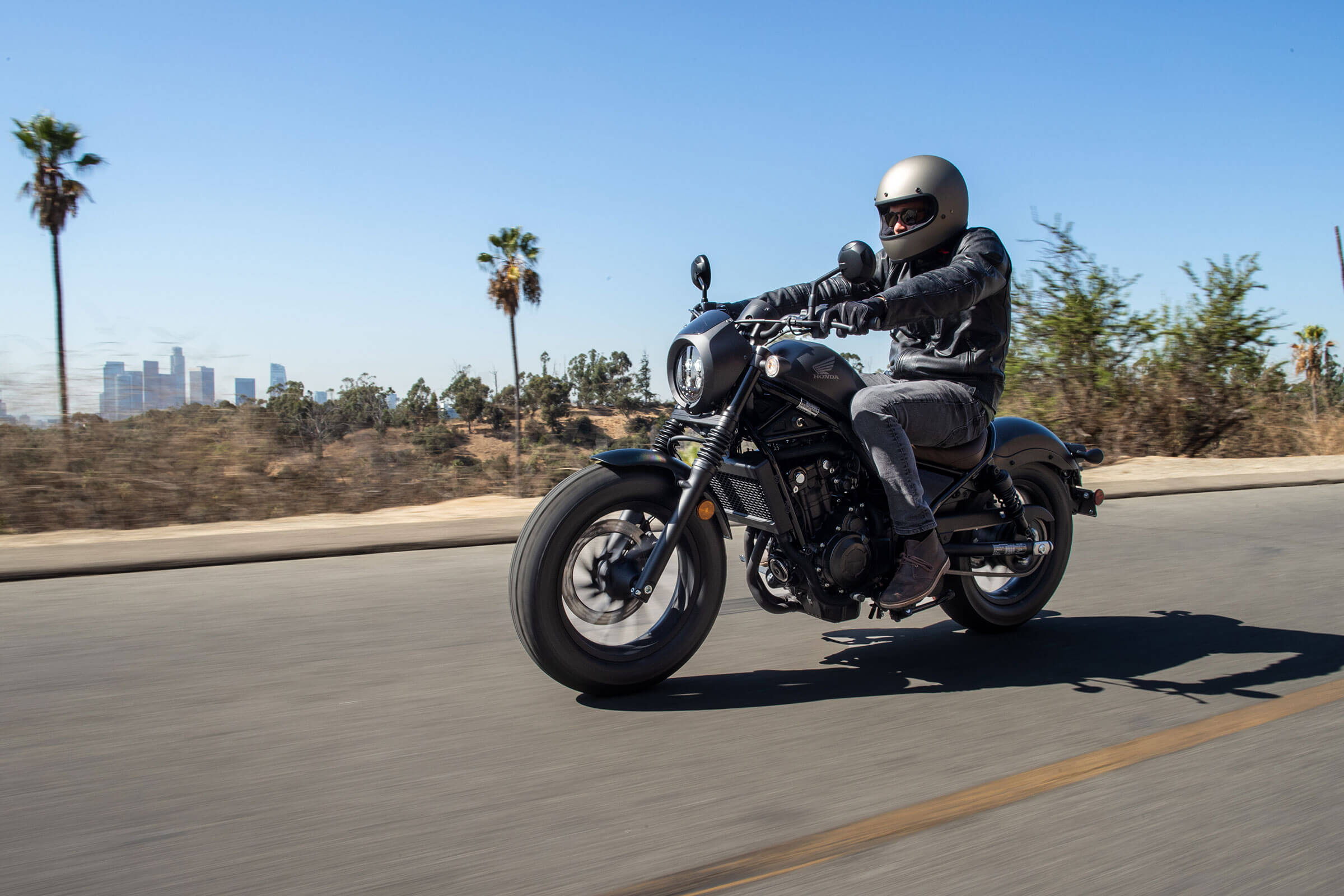 A rider cruising down the highway on the 2022 Honda Rebel 500