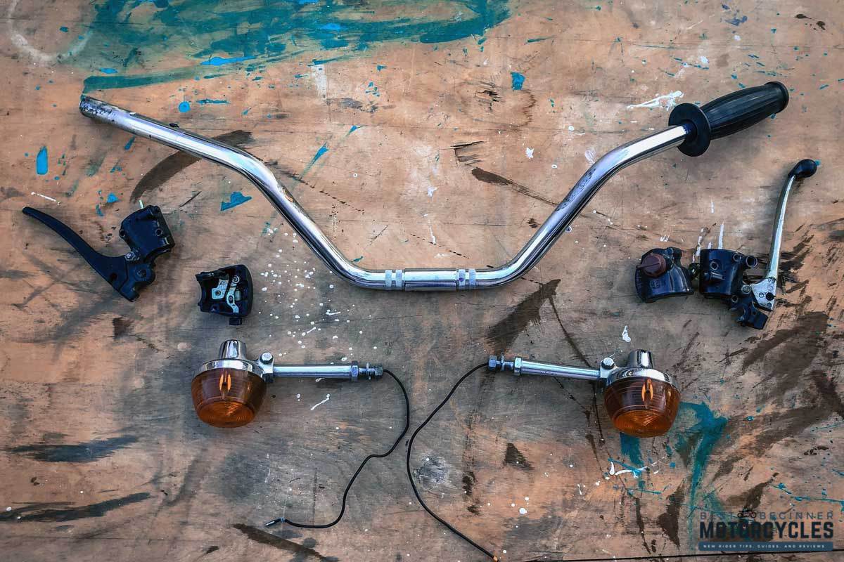 parts of a motorcycle's handlebars laid out on a table ready for installation