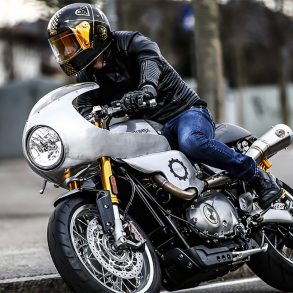 Rider taking corner on motorcycle with custom modifications