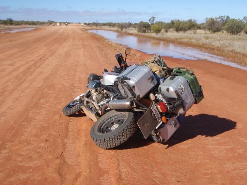 BMW R 1200 GS on side in red dirt with car tyre mounted on rear wheel