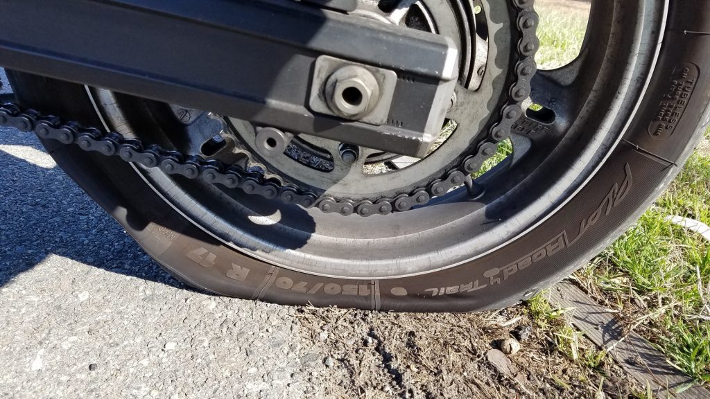 a partially deflated motorcycle tyre on a driveway