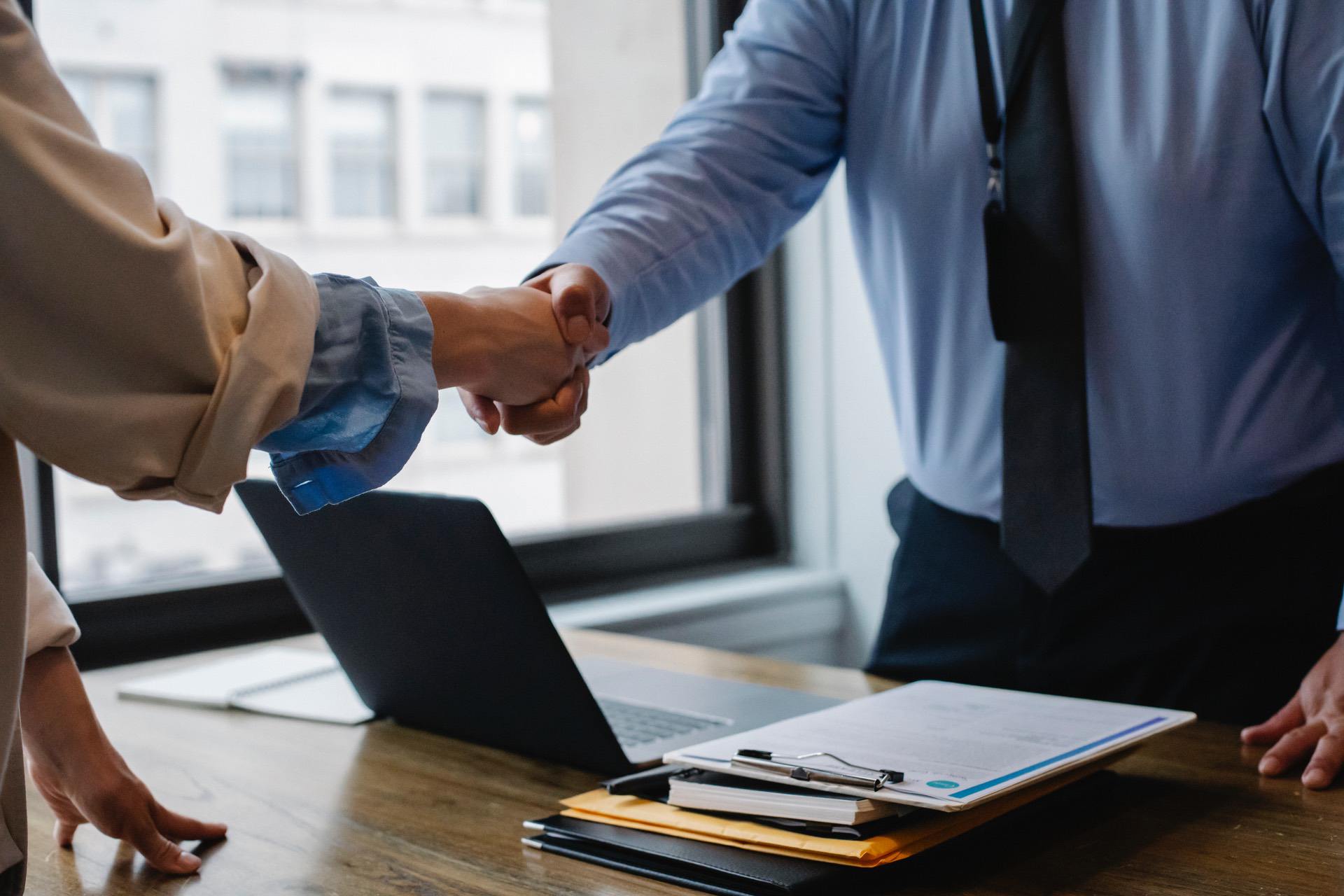 Insurance agent shaking hands with client after agreeing on policy