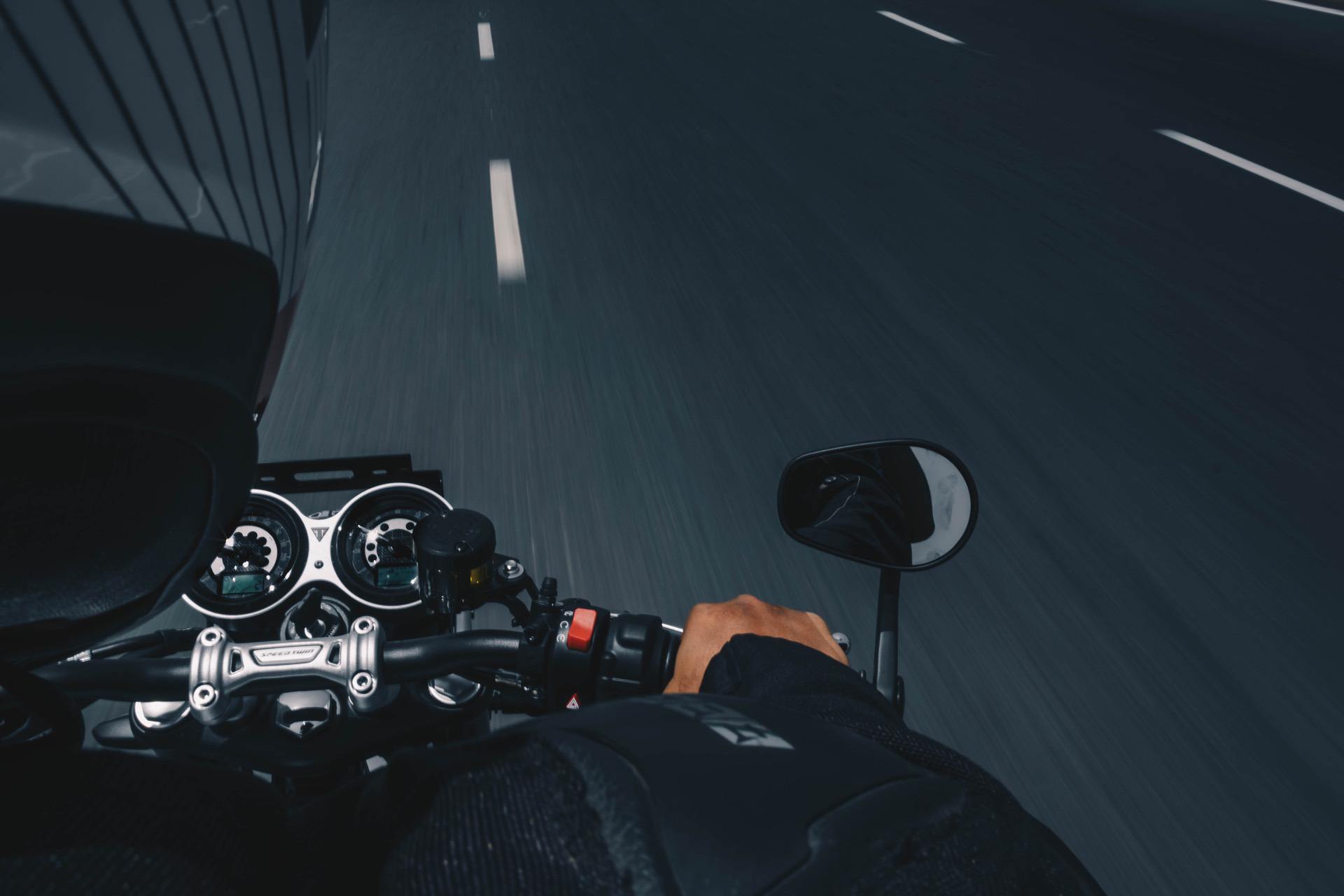 Road blurring while motorcyclist rides down highway at speed