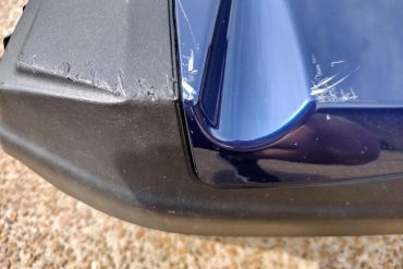 Scratched paint on blue motorcycle fairing