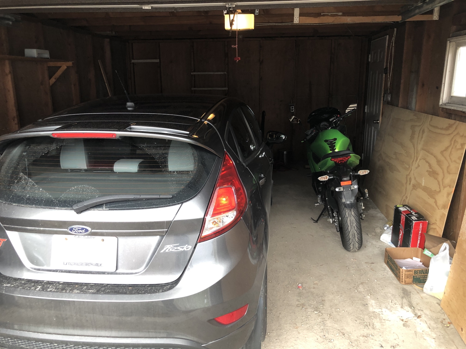 Ninja 650 next to Ford Fiesta in garage