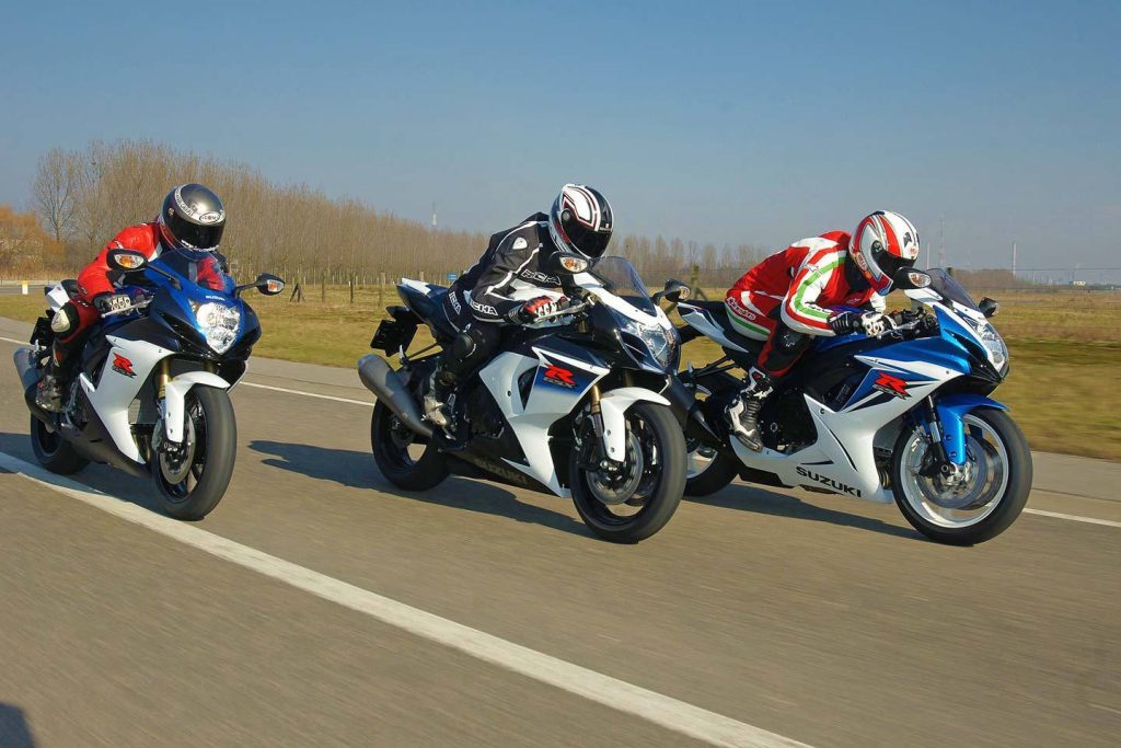 Three sportsbike motorcycle riders race each other on a public road