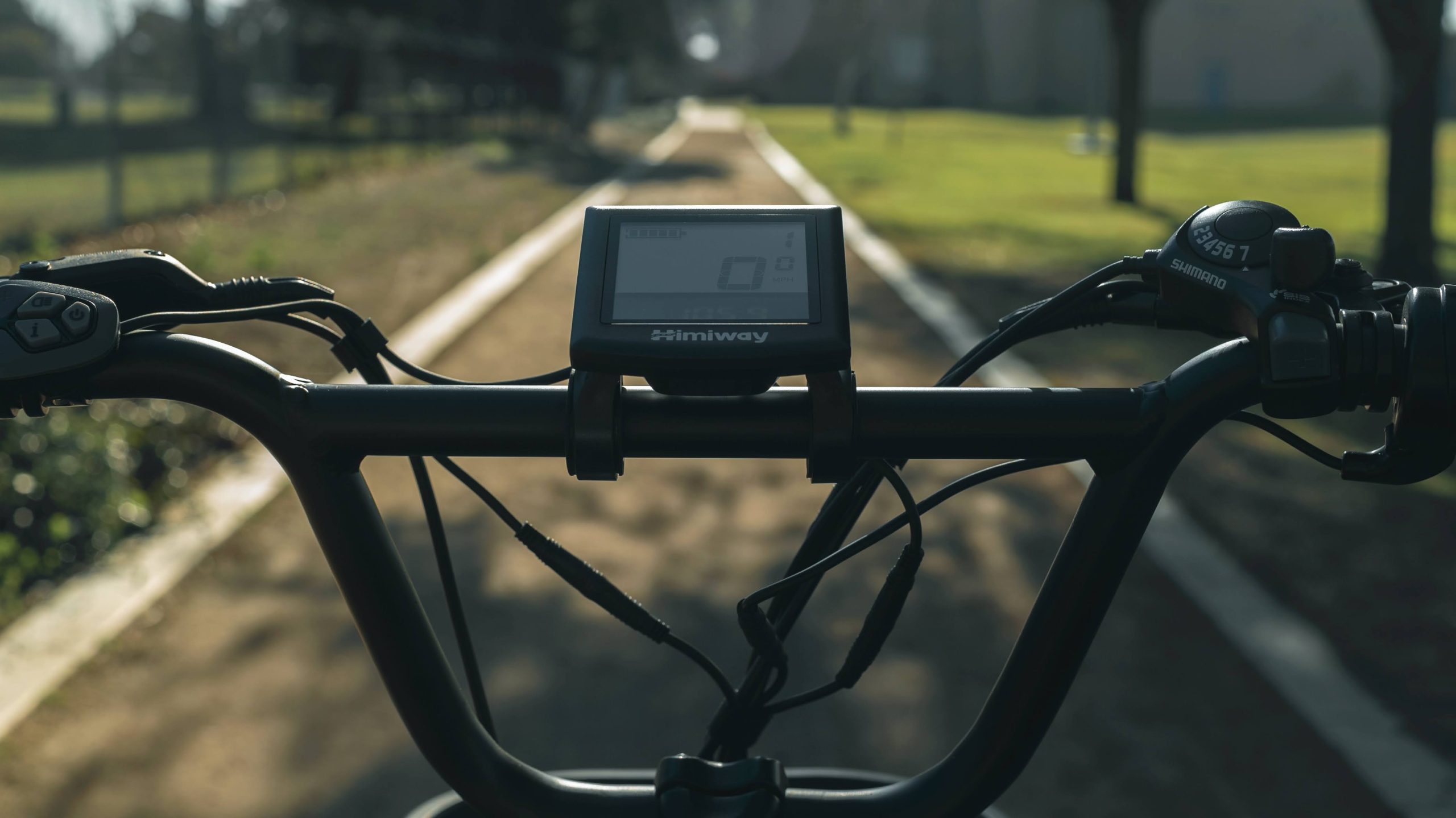 Close-up shot of Himiway eBike display and handlebars with out of focus urban backdrop