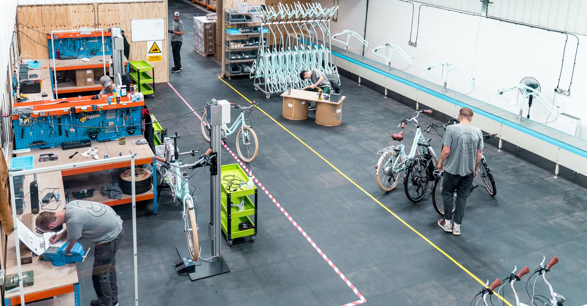 Five men in a factory working to manufacture and produce electric bicycles