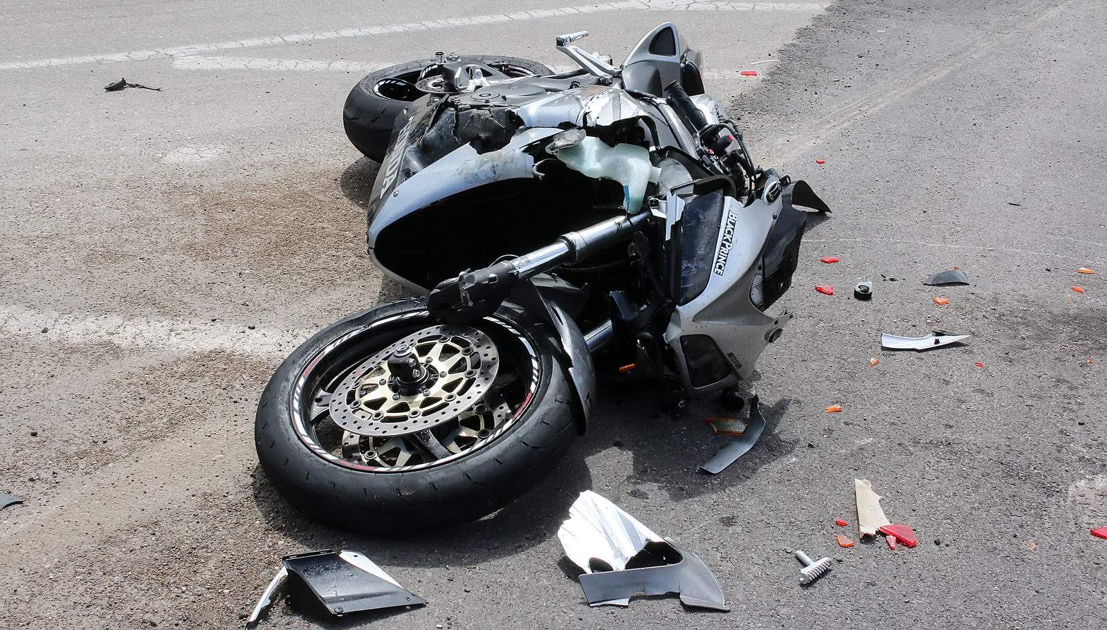 sports motorcycle lays on a road after an accident