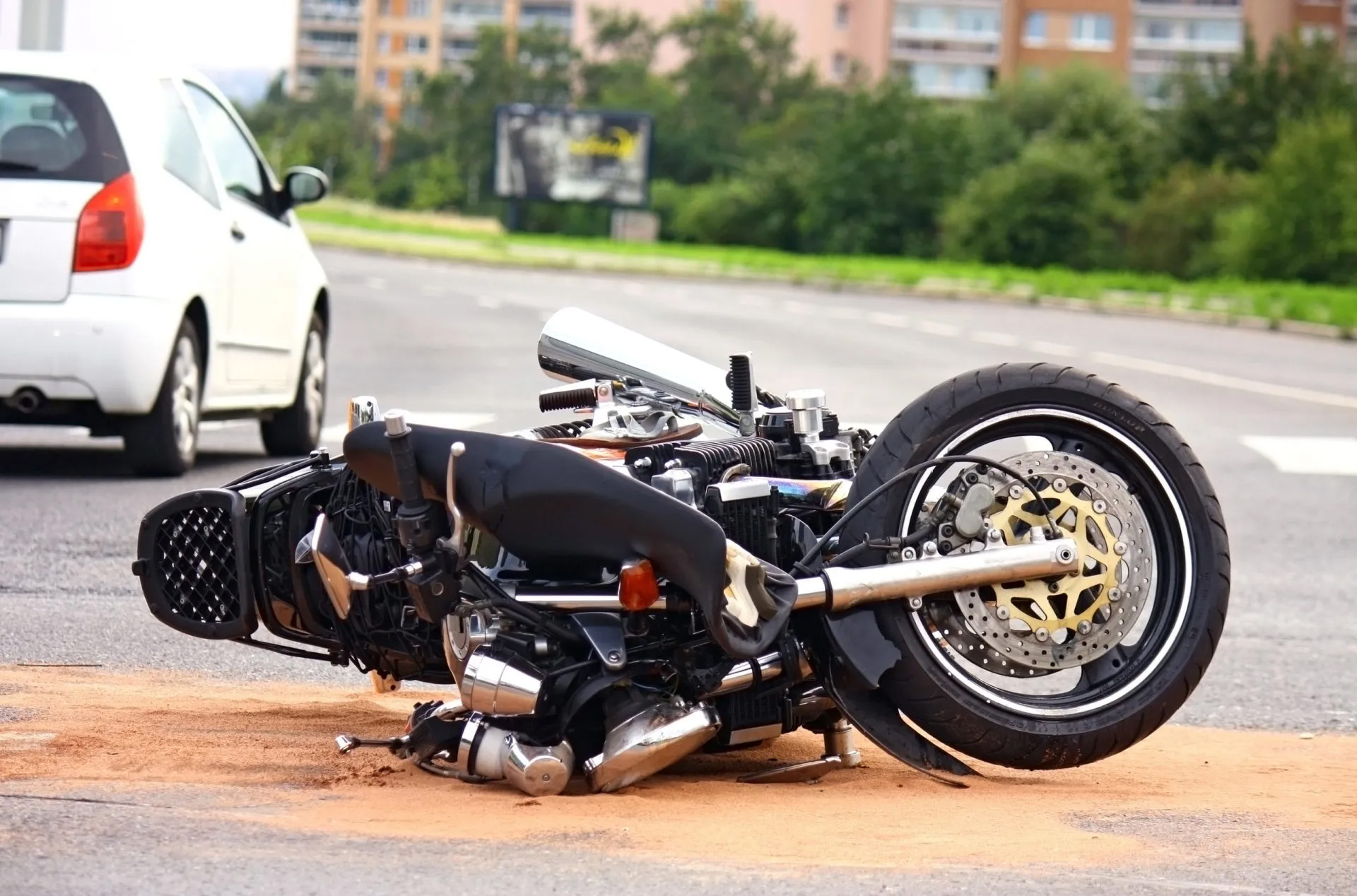 motorcycle rests on its side in the middle of a road after an accident