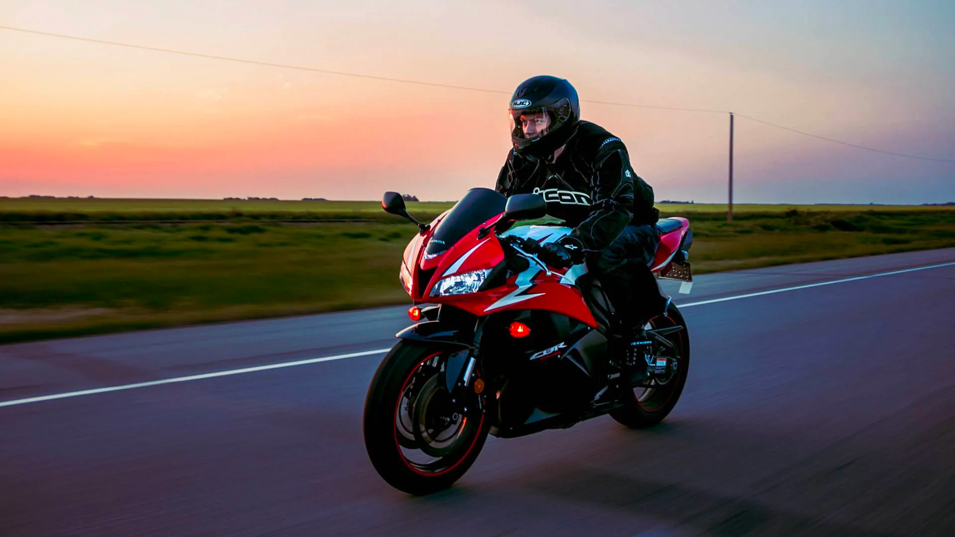 motorcycle rider on a Honda sportsbike riding at sunset in the countryside