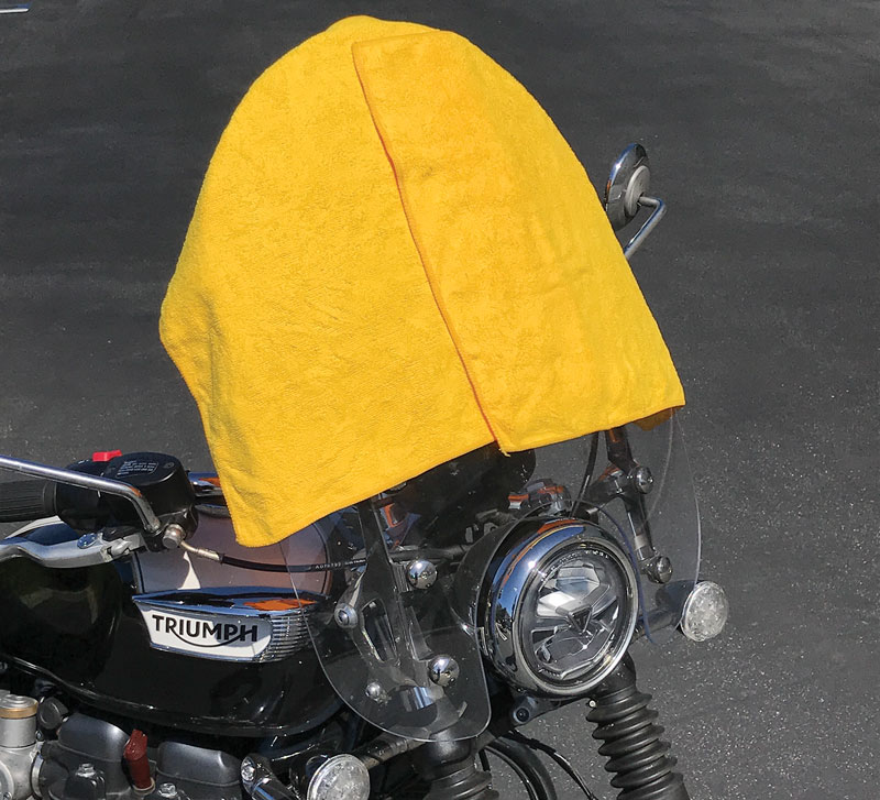 Towels over a motorcycle windshield to protect from the sun