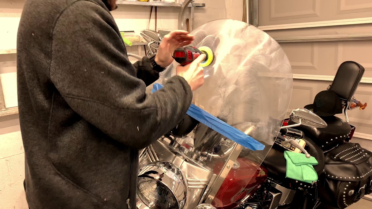 Specialist polishing a motorcycle windshield