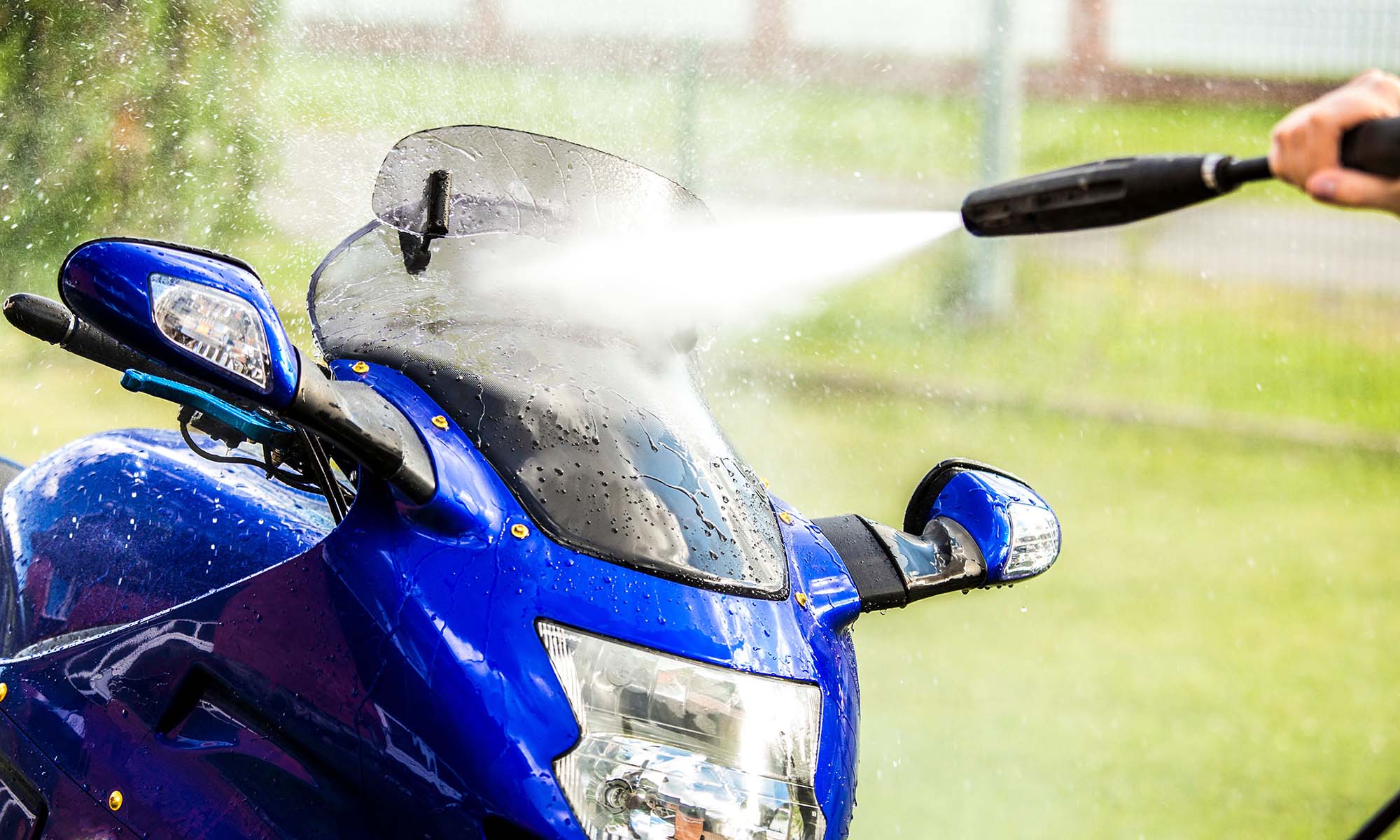 Washing the windscreen of a motorcycle with a pressure washer