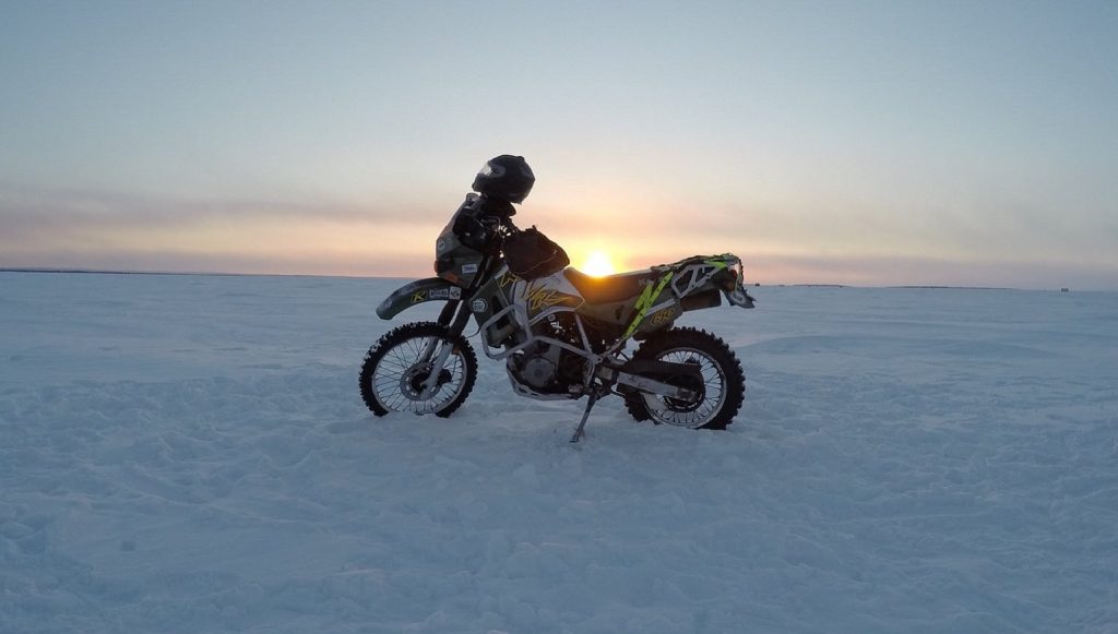 A fully winterized dual-sport bike on a snow-covered field