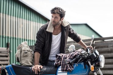 Portrait of man leaning on motorcycle