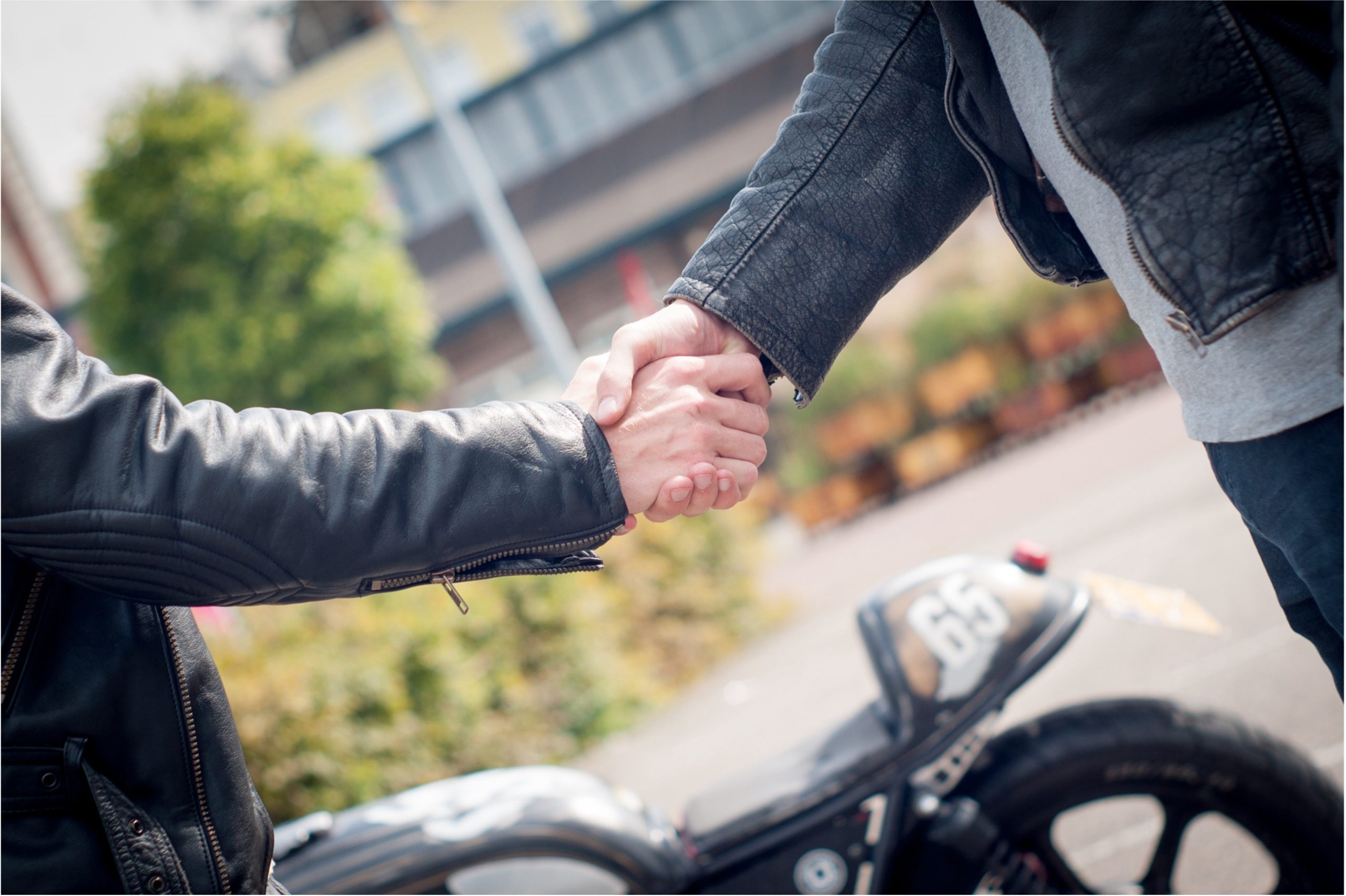 Buyer and seller shaking hands after completing a motorcycle sale transaction