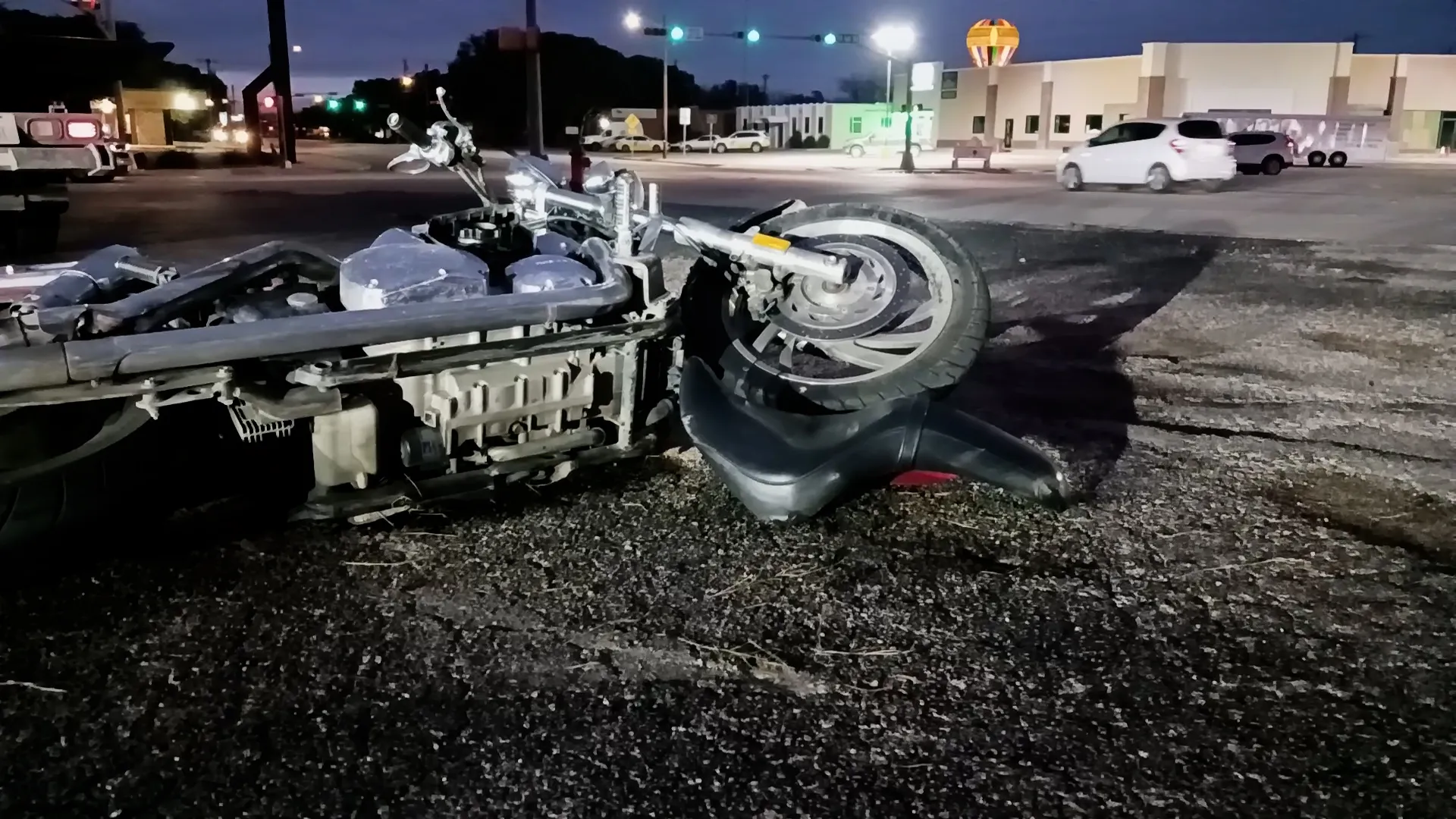 Wrecked motorcycle on a city street at night